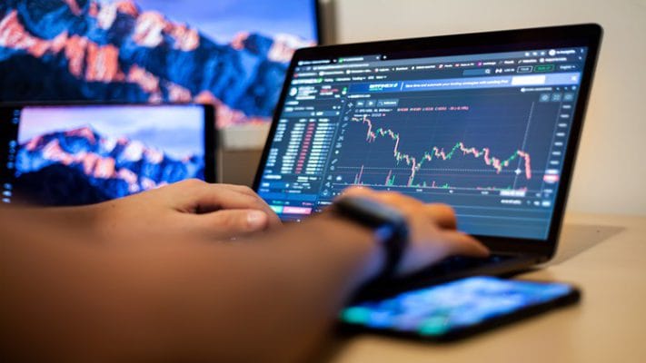 A man working on a stock chart on a laptop